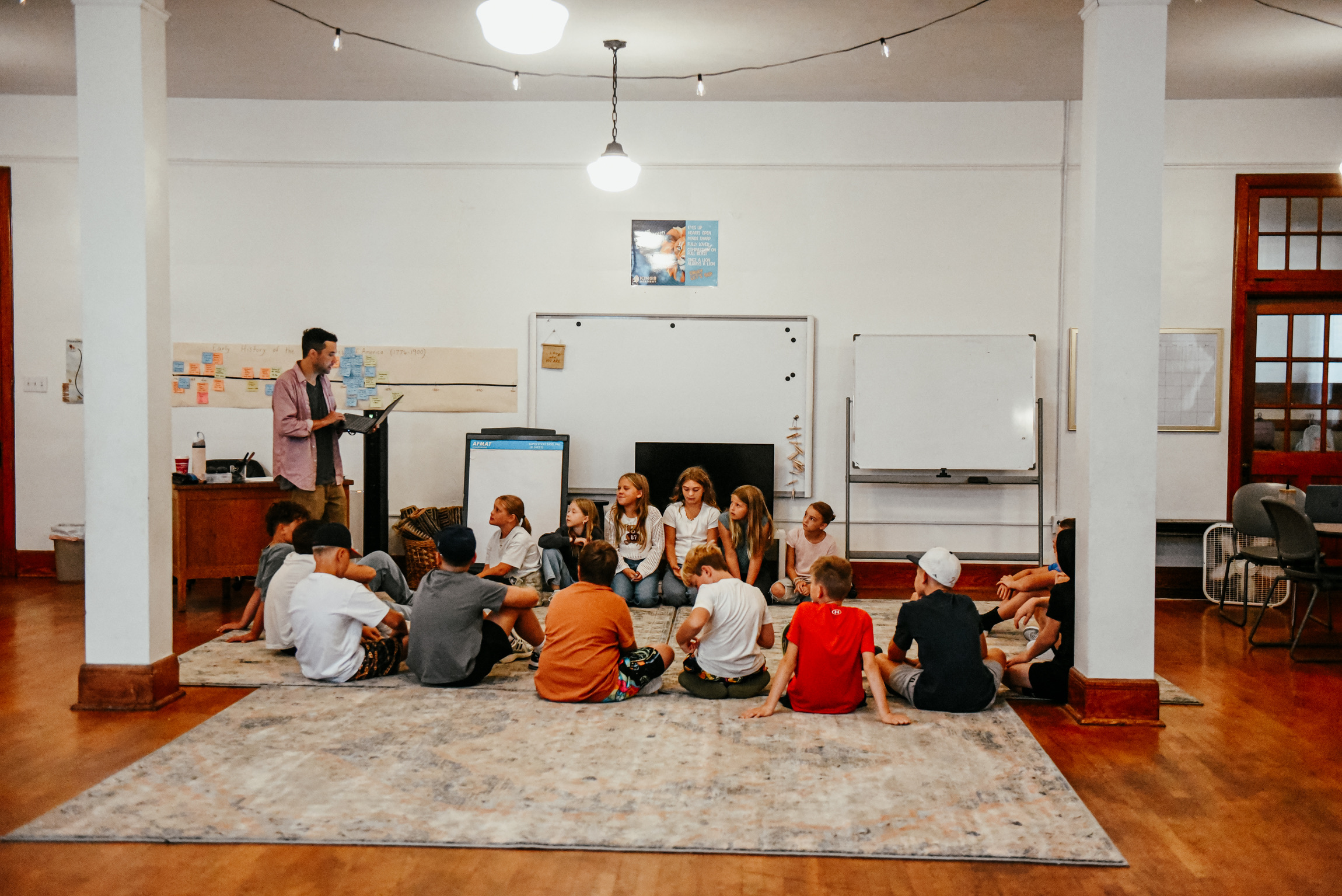 A guide leading Discovery Studio learners gathered on the rug