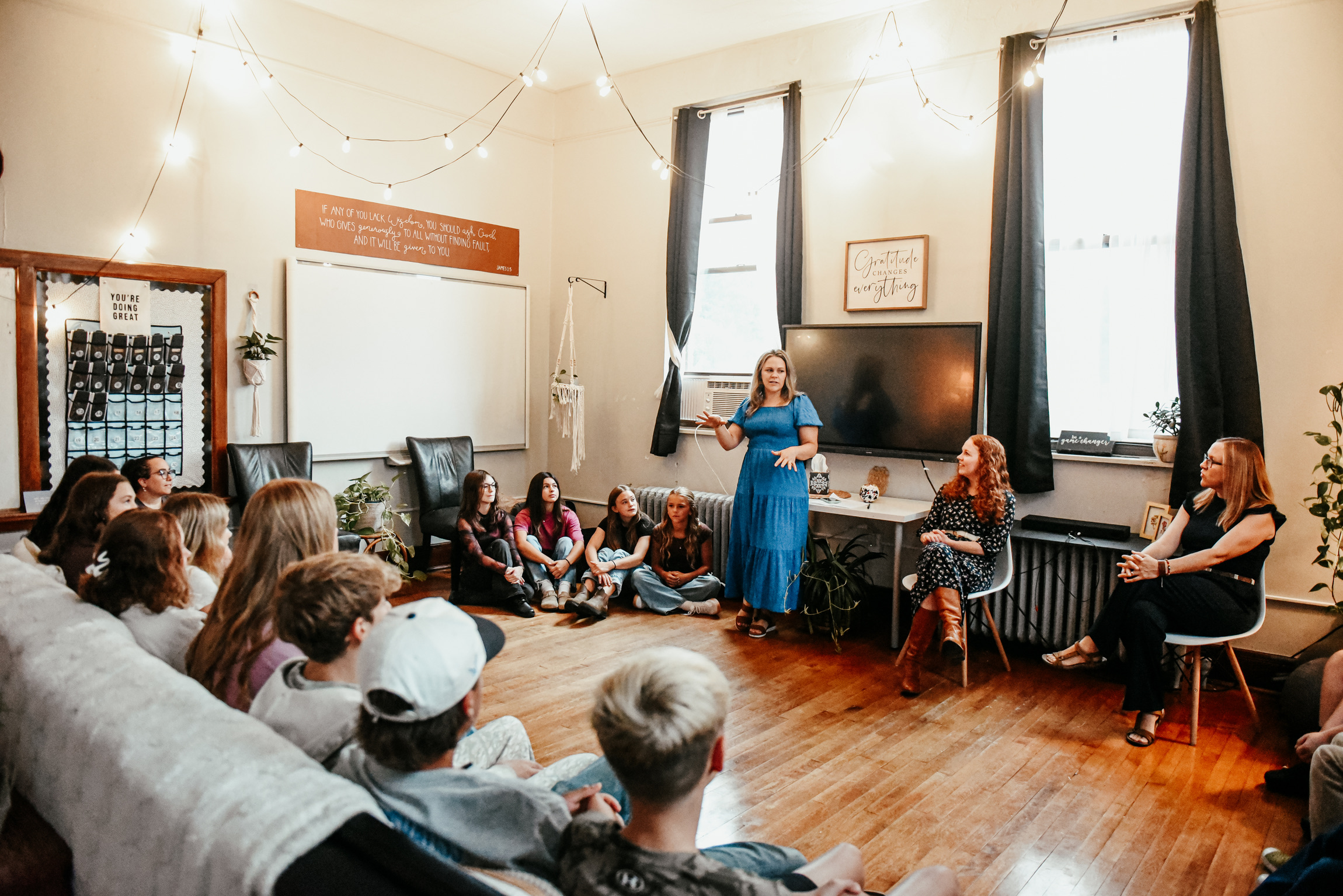 A guide leading a studio discussion with learners gathered in a circle